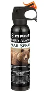 Counter Assault bear spray in holster on a hiking pack hip belt on a mountain trail