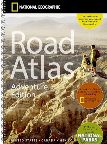 Rand McNally road atlas open to a state map on a car dashboard during a road trip